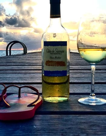 Wine and sandals with a sunset in the background