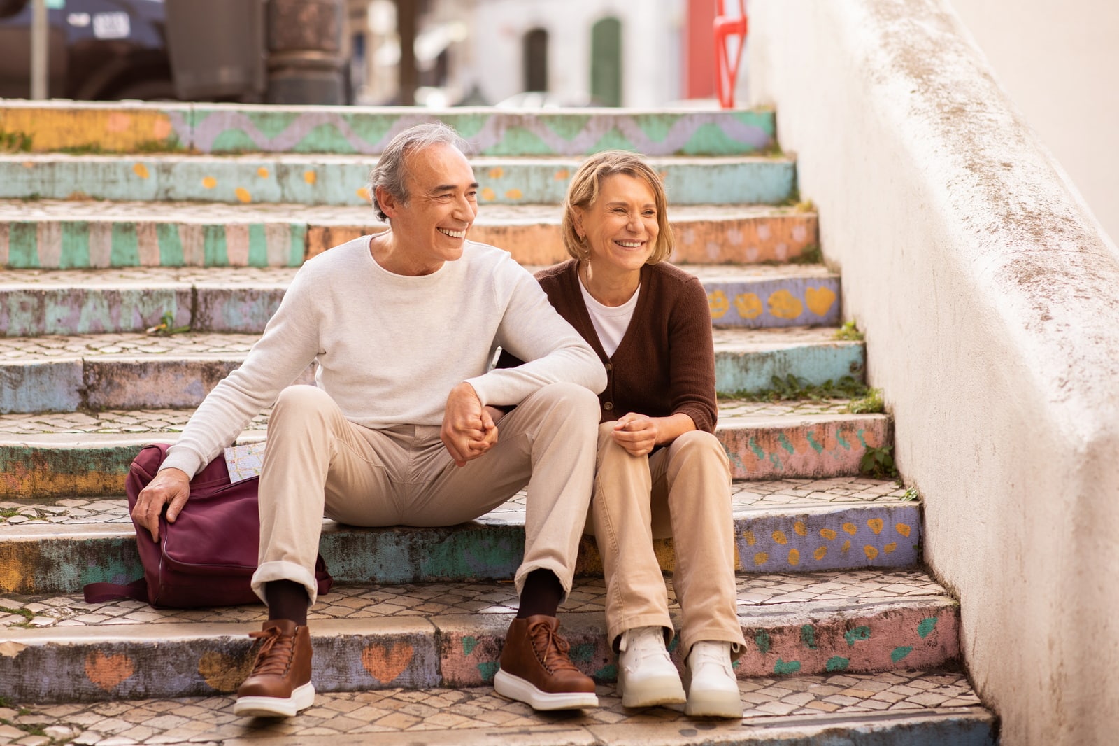 A retired couple on beautifully tiled steps in Europe