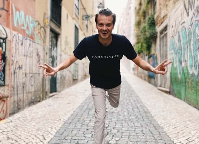 A happy man in a road in Portugal, one of the cheapest places to live in Europe.