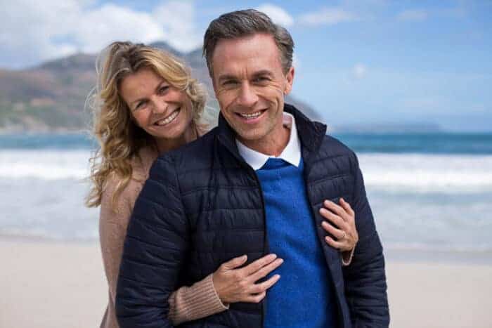 A retired couple hugging on the beach in Panama