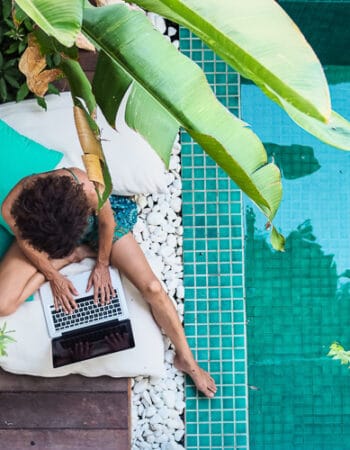 A lady working remotely next to a pool