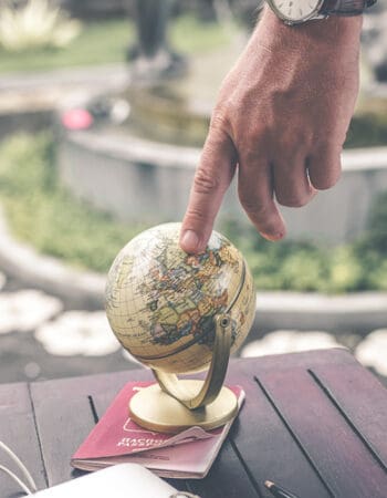 Man looking at a globe to decide on residency
