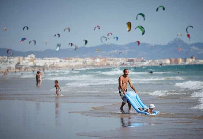 A man and his child on a beach, living in Spain