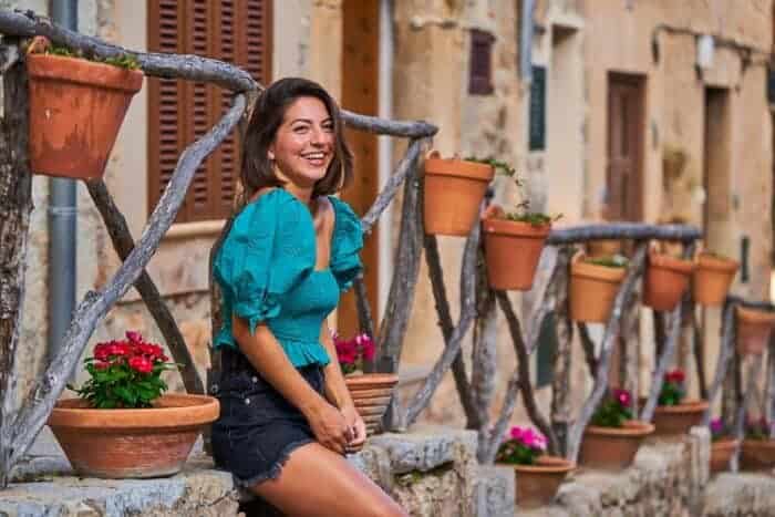 A woman smiling outside her house in Spain