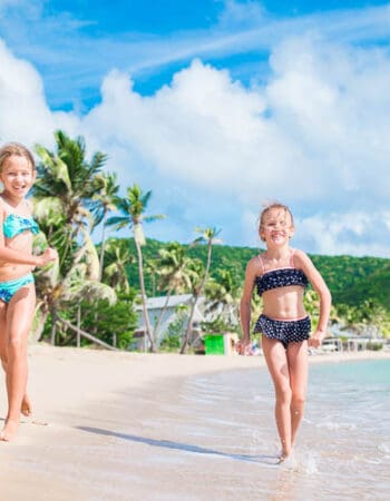 Two grils running on a beach in Barbados