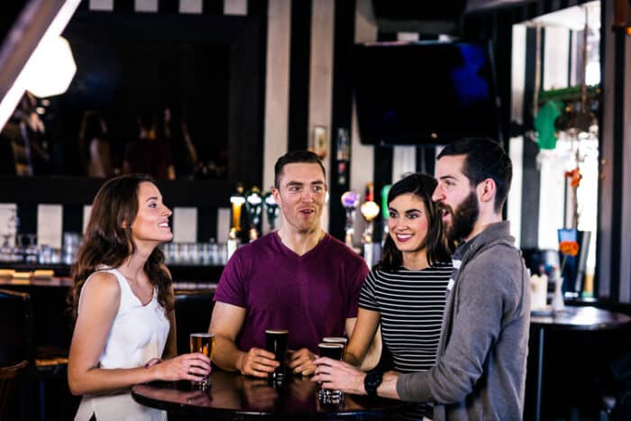 Friends enjoying living in Ireland having a pint in an Irish pub