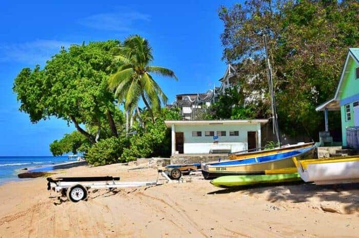 A boat on a beach in Barbados.  An activity that those with Barbados citizenship enjoy.