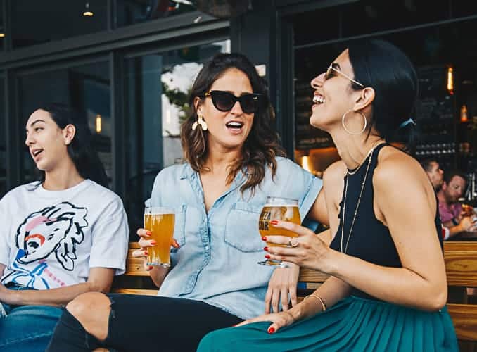 Two women holding beers celebrating their new life living in Czech Republic