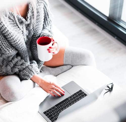 A woman enjoying a cup of tea thanks to her remote work in a different country