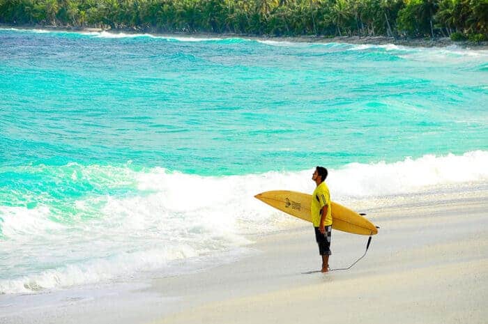 A surfer in the Carribean in Barbados on a Welcome Stamp Visa