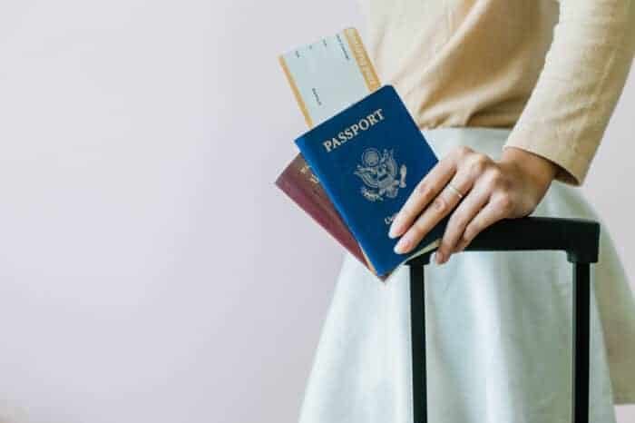 A lady holding two passports in her hand