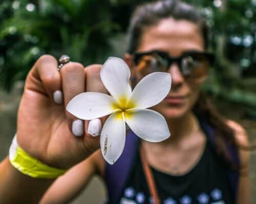 A woman in Panama holding a white tropical flower