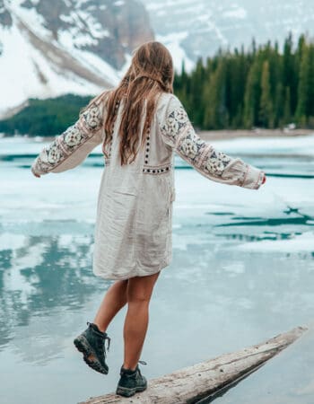 A girl walking next to a lake in Canada