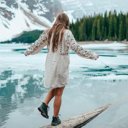 A girl walking next to a lake in Canada