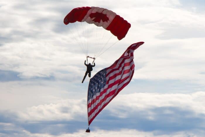 A skydiver with the Canada and USA flags