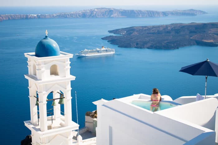 A woman living in Greece looking over the rooftops of the white buidlings