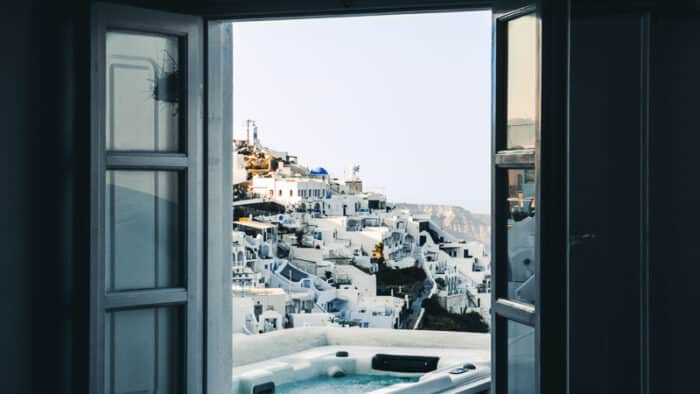 View out of a window in Greece of the white houses with blue roofs