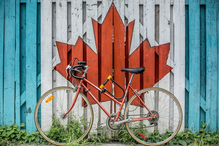 A bike in front of a maple leaf representing Canada citizenship