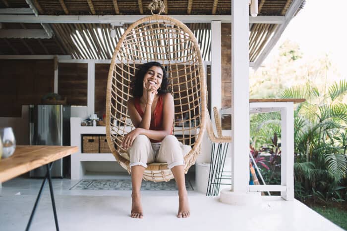 Happy woman in a wicker chair on her porch in Costa Rica