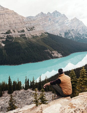 A man sitting next to a beautiful lake in Canada