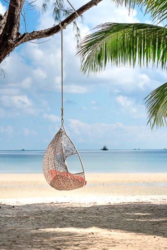 Someone in a swing chair on a beach in Costa Rica