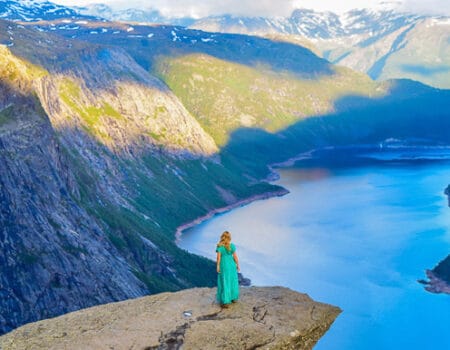 Girl in the beautiful dress on the edge of cliff on Trolltung, Norway.