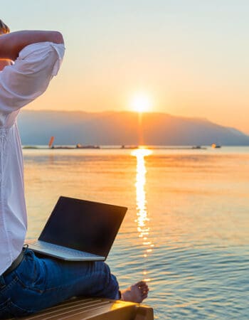 Remote worker with laptop in the morning on the beach working