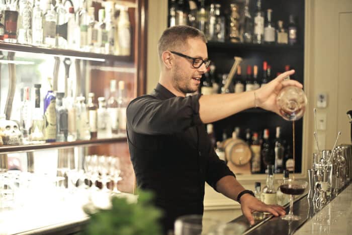A barman manking a cocktail.  This is a profession on the skilled migration programs around the world.