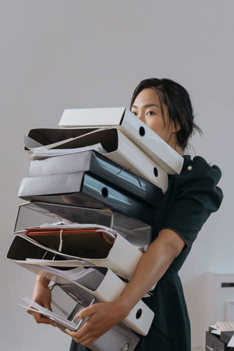 A lady carrying a lot of books and files